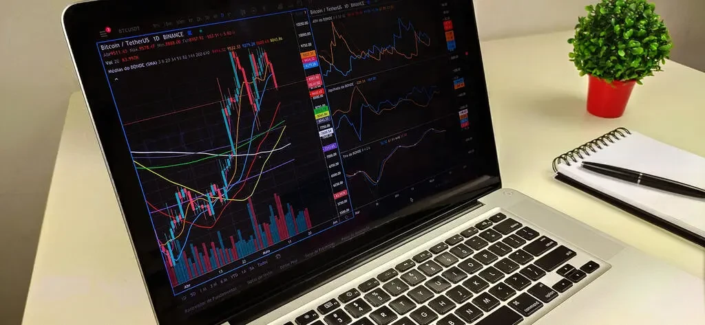 um computador conectado no site da okx em um grafico de criptomoedas