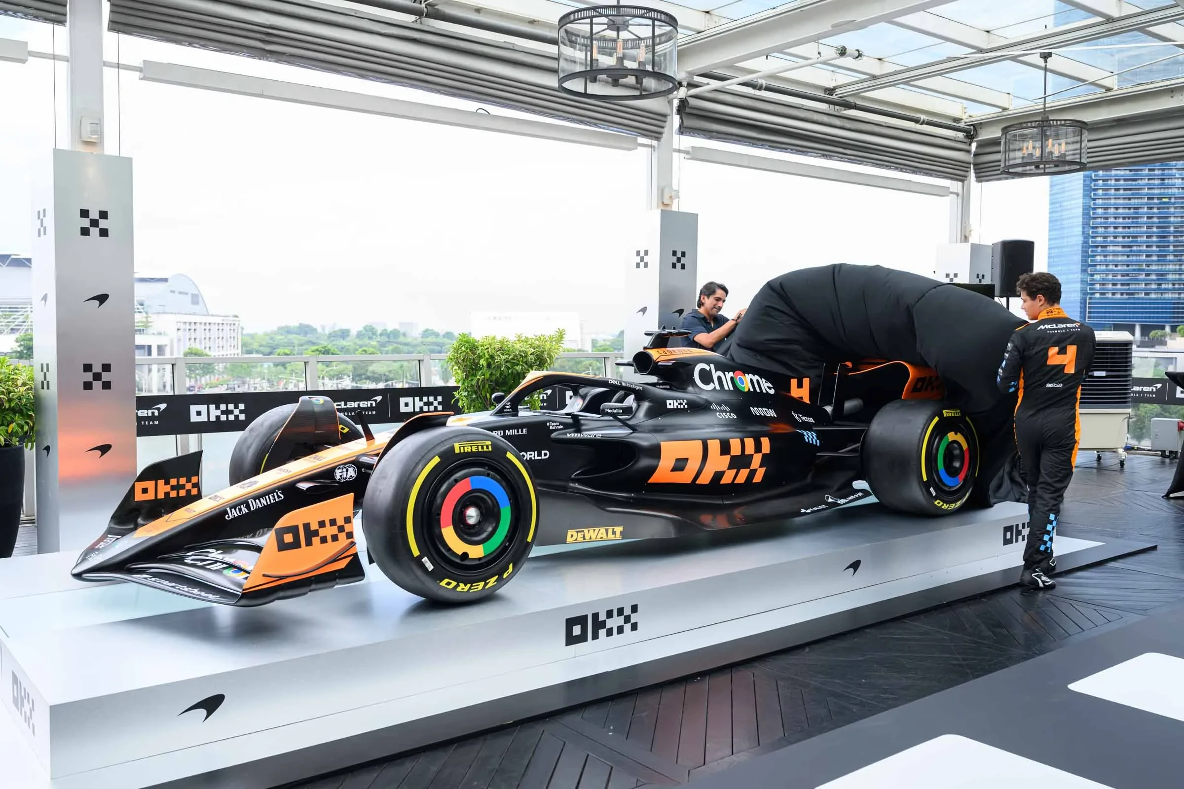 Haider Rafique and Lando Norris unveiling the MCL60 F1 car in a limited edition Stealth Mode livery - switching McLaren’s livery colorway by adding black to the team’s classic papaya trim